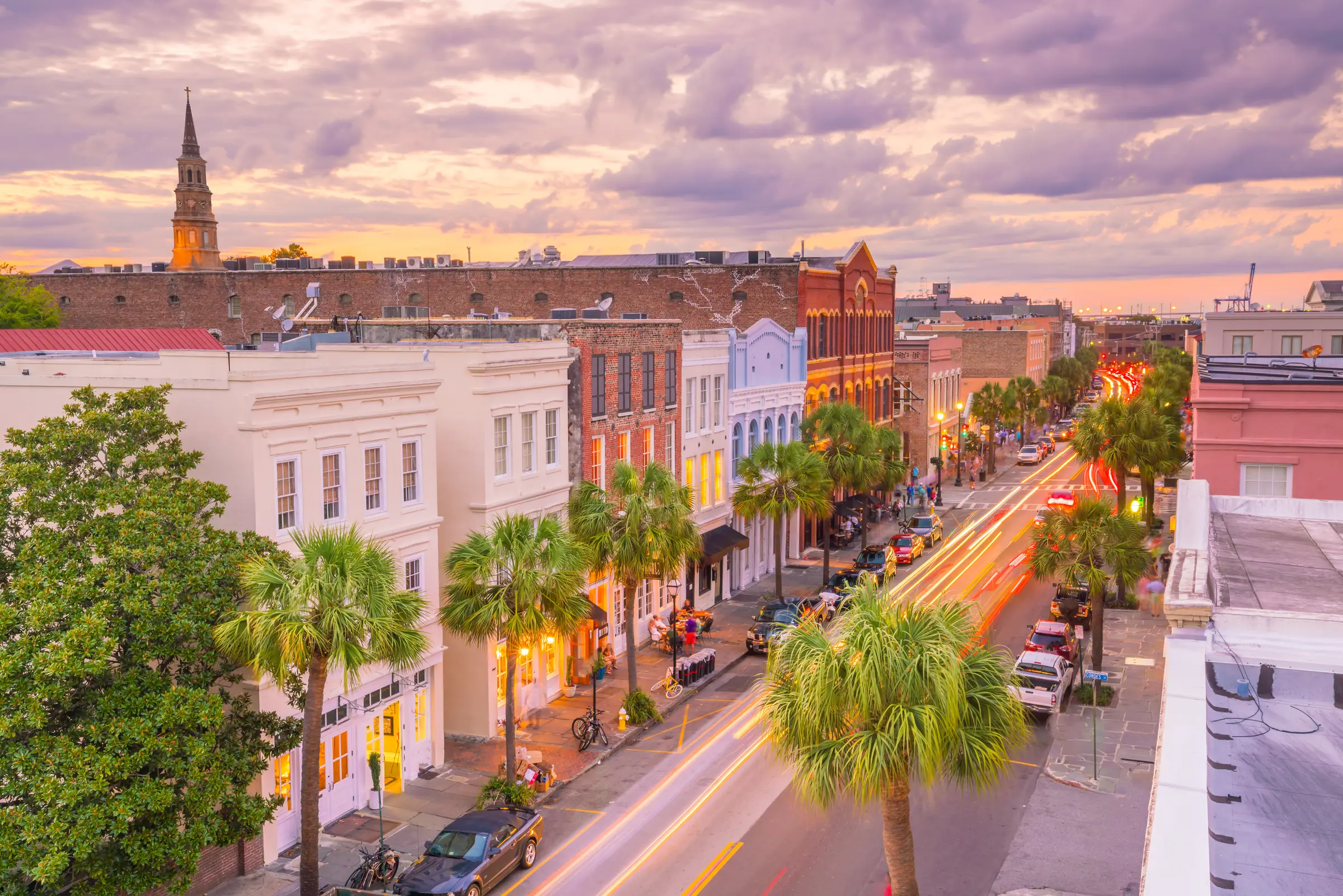 Downtown Charleston, SC rooftops and palm-lined street at sunset